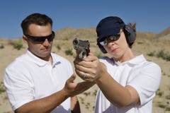 Instructor Assisting Woman With Hand Gun stock photo Instructor Assisting Woman With Hand Gun stock photo