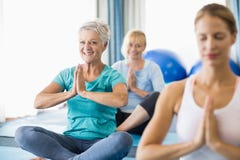 Instruktör som utför yoga med pensionärer royaltyfri foto Instruktör som utför yoga med pensionärer royaltyfri foto