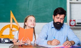 Interesting book. back to school. Private teaching. private lesson. small girl child with bearded teacher man in royalty free stock photos Interesting book. back to school. Private teaching. private lesson. small girl child with bearded teacher man in royalty free stock photos
