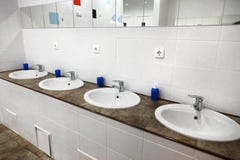 Interior público do banheiro dos homens do toalete vazio com os dissipadores da mão da lavagem imagens de stock Interior público do banheiro dos homens do toalete vazio com os dissipadores da mão da lavagem imagens de stock