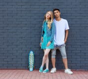 Interracial young couple in love outdoor whis skateboard. Stunning sensual outdoor portrait of young stylish fashion couple posing stock photo Interracial young couple in love outdoor whis skateboard. Stunning sensual outdoor portrait of young stylish fashion couple posing stock photo