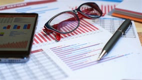 Investment Charts And Stock Statistics. Mobile Phone, Pen And Cup Of Coffee Investment Charts And Stock Statistics. Mobile Phone, Pen And Cup Of Coffee