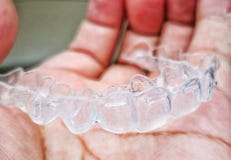 Invisalign or invisible braces, a orthodontic equipment on a hand.