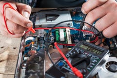Inżynier wręcza diagnostyka laptop z multimeter zdjęcie stock Inżynier wręcza diagnostyka laptop z multimeter zdjęcie stock