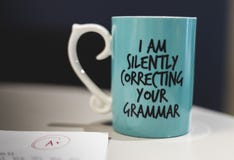 “Io che correggo silenziosamente tazza da caffè della vostra grammatica “ immagini stock libere da diritti “Io che correggo silenziosamente tazza da caffè della vostra grammatica “ immagini stock libere da diritti
