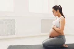 Ioga do treinamento da mulher gravida na pose dos lótus foto de stock Ioga do treinamento da mulher gravida na pose dos lótus foto de stock
