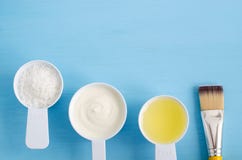 Iogurte grego do creme de leite, coco shredded e azeite no colheres pequenas Os ingredientes para preparar máscaras diy, esfregam fotos de stock Iogurte grego do creme de leite, coco shredded e azeite no colheres pequenas Os ingredientes para preparar máscaras diy, esfregam fotos de stock