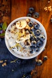 Iogurte natural com os mirtilos, as bananas e o muesli orgânicos da adição imagens de stock royalty free Iogurte natural com os mirtilos, as bananas e o muesli orgânicos da adição imagens de stock royalty free