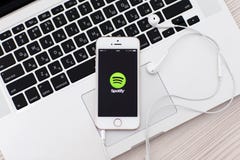 IPhone blanc 5s avec le site Spotify sur l'écran et les écouteurs l IPhone blanc 5s avec le site Spotify sur l'écran et les écouteurs l