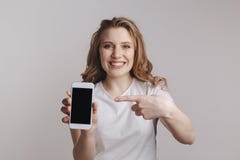 Iphone удерживания молодой женщины Handsopme белое изолированное над белой предпосылкой стоковая фотография Iphone удерживания молодой женщины Handsopme белое изолированное над белой предпосылкой стоковая фотография