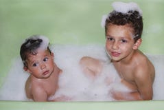 Irmão e irmã banhados em um banho de espuma. imagens de stock Irmão e irmã banhados em um banho de espuma. imagens de stock