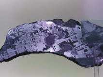 Iron alien meteorite with Widmanstatten pattern on light royalty free stock photo Iron alien meteorite with Widmanstatten pattern on light royalty free stock photo