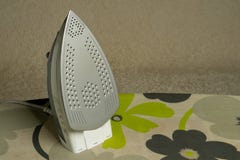 Iron stands on a multi-colored ironing board royalty free stock image Iron stands on a multi-colored ironing board royalty free stock image