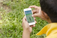 Isla de Samui, Tailandia - agosto 8,2016 Apple sirve con iPhone5s sostenido en una mano que muestra que va su pantalla con Pokemo foto de archivo Isla de Samui, Tailandia - agosto 8,2016 Apple sirve con iPhone5s sostenido en una mano que muestra que va su pantalla con Pokemo foto de archivo
