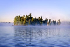 Island in lake with morning fog Royalty Free Stock Photography Island in lake with morning fog Royalty Free Stock Photography