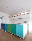 Isola di cucina progettata nella cucina aperta di piano sui rulli industriali, sulla retro progettazione dipinti nei colori blu e immagini stock libere da diritti Isola di cucina progettata nella cucina aperta di piano sui rulli industriali, sulla retro progettazione dipinti nei colori blu e immagini stock libere da diritti