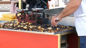 Istanbul, Turkey - June 12, 2019: Roasted chestnuts on a city street. Street food, the hot cooked chestnuts stock footage Istanbul, Turkey - June 12, 2019: Roasted chestnuts on a city street. Street food, the hot cooked chestnuts stock footage