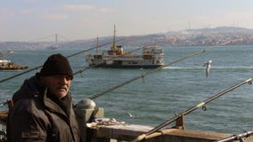 Istanbul, Turquie - vieux pêcheur à la ligne dans le pont de Galata pendant l'hiver photo libre de droits Istanbul, Turquie - vieux pêcheur à la ligne dans le pont de Galata pendant l'hiver photo libre de droits