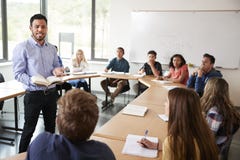 Istitutore maschio With Pupils Sitting della High School alla classe d'istruzione di per la matematica della Tabella fotografia stock libera da diritti Istitutore maschio With Pupils Sitting della High School alla classe d'istruzione di per la matematica della Tabella fotografia stock libera da diritti