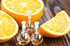 Istotny aromata olej w szklanej butelce z świeżą, soczystą, dojrzałą, pomarańczową owoc na drewnianym tle, kąpielowy piękna skład zdjęcia royalty free Istotny aromata olej w szklanej butelce z świeżą, soczystą, dojrzałą, pomarańczową owoc na drewnianym tle, kąpielowy piękna skład zdjęcia royalty free