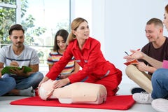 Istruttore che dimostra CPR sul manichino alla classe del pronto soccorso fotografia stock Istruttore che dimostra CPR sul manichino alla classe del pronto soccorso fotografia stock