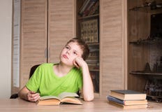 Istruzione e concetto della scuola Ragazzo teenager che legge un libro a casa immagine stock libera da diritti Istruzione e concetto della scuola Ragazzo teenager che legge un libro a casa immagine stock libera da diritti