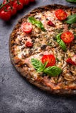 Italiaanse pizza op zwart deeg In voedsel Royalty-vrije Stock Afbeeldingen Italiaanse pizza op zwart deeg In voedsel Royalty-vrije Stock Afbeeldingen