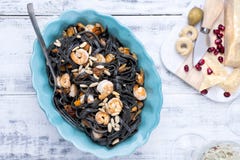 Italian Pasta is black with mussels and shrimps. Parmesan, Seafood, various snacks for dinner. Bright dishes and white background stock image Italian Pasta is black with mussels and shrimps. Parmesan, Seafood, various snacks for dinner. Bright dishes and white background stock image