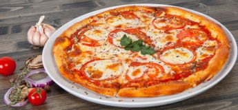 Italian pizza with tomato topped with melted golden cheese, herbs and basil Royalty Free Stock Images Italian pizza with tomato topped with melted golden cheese, herbs and basil Royalty Free Stock Images