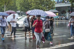 It’s que llueve por la mañana, y los peatones que caminan a través del camino pasan por la intersección foto de archivo libre de regalías It’s que llueve por la mañana, y los peatones que caminan a través del camino pasan por la intersección foto de archivo libre de regalías