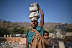 Jaipur, Inde, le 1er décembre 2017 : La femme travaillant dur des soins lapide porter l'enfant sur le dos photos stock Jaipur, Inde, le 1er décembre 2017 : La femme travaillant dur des soins lapide porter l'enfant sur le dos photos stock