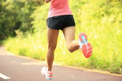Jambes de femme de forme physique fonctionnant à la traînée de forêt photo stock Jambes de femme de forme physique fonctionnant à la traînée de forêt photo stock