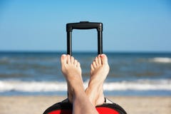 Jambes du ` s de femmes dans des chaussures sur une valise de voyage à l'arrière-plan d'océan photo stock Jambes du ` s de femmes dans des chaussures sur une valise de voyage à l'arrière-plan d'océan photo stock