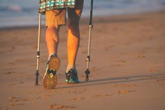 Jambes et poteaux de dame âgée nordique de marcheur sur la plage photos stock Jambes et poteaux de dame âgée nordique de marcheur sur la plage photos stock