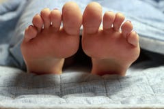 Jambes femelles, pieds sur le lit, vue de face, concept de sommeil sain photos stock Jambes femelles, pieds sur le lit, vue de face, concept de sommeil sain photos stock