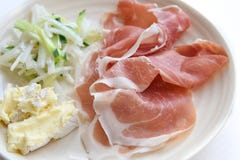 Jambon de Prosciutto avec du fromage et la salade à l'arrière-plan blanc Photos stock Jambon de Prosciutto avec du fromage et la salade à l'arrière-plan blanc Photos stock