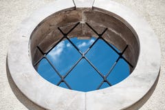 Janela medieval redonda com opinião de céu azul das barras - fundo abstrato do conceito - dentro fora conceito - janela redonda c fotografia de stock Janela medieval redonda com opinião de céu azul das barras - fundo abstrato do conceito - dentro fora conceito - janela redonda c fotografia de stock