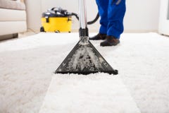 Janitor καθαρίζοντας τάπητας με την ηλεκτρική σκούπα Janitor καθαρίζοντας τάπητας με την ηλεκτρική σκούπα