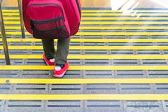 Japanese guy walking down the stair at the train station with the guitar backpack on his back royalty free stock image Japanese guy walking down the stair at the train station with the guitar backpack on his back royalty free stock image