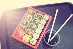 Japanse sushi in rode plastic container voor het dragen van voedsel op zwarte Broodje van krabvlees wordt gemaakt, avocado, komko stock afbeelding Japanse sushi in rode plastic container voor het dragen van voedsel op zwarte Broodje van krabvlees wordt gemaakt, avocado, komko stock afbeelding