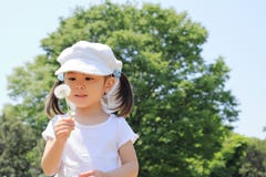 Japansk flicka som blåser maskrosfrö under den blåa himlen fotografering för bildbyråer Japansk flicka som blåser maskrosfrö under den blåa himlen fotografering för bildbyråer