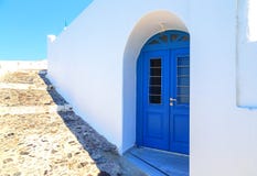 Jaskrawi błękitni drzwi, żaluzje i perfect biel, myli ściany w tylnych ulicach fira, Santorini, Grecja obrazy stock Jaskrawi błękitni drzwi, żaluzje i perfect biel, myli ściany w tylnych ulicach fira, Santorini, Grecja obrazy stock