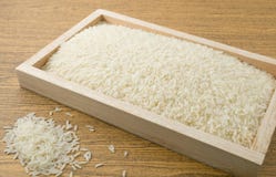 Jasmine Rice dans un plateau en bois de Brown image libre de droits Jasmine Rice dans un plateau en bois de Brown image libre de droits