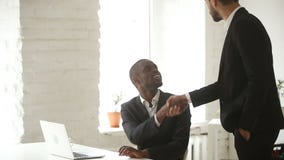 Jefe caucásico que agradece felicitando al encargado africano con la promoción por el apretón de manos almacen de video Jefe caucásico que agradece felicitando al encargado africano con la promoción por el apretón de manos almacen de video