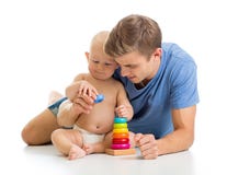 Jeu de bébé garçon et de père ainsi que le jouet de pyramide Image stock Jeu de bébé garçon et de père ainsi que le jouet de pyramide Image stock