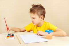 Jeune artiste dans la chemise jaune allant peindre des couleurs photographie stock Jeune artiste dans la chemise jaune allant peindre des couleurs photographie stock