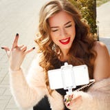 Jeune belle femme dans le chapeau faisant le selfie montrant dehors la roche Photos stock Jeune belle femme dans le chapeau faisant le selfie montrant dehors la roche Photos stock
