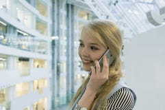 jeune blonde parlant au téléphone sur le fond des planchers d'un centre commercial moderne profondeur de champ, tache floue photos stock jeune blonde parlant au téléphone sur le fond des planchers d'un centre commercial moderne profondeur de champ, tache floue photos stock