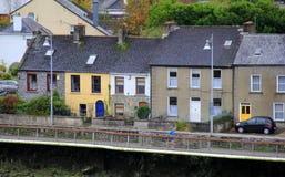 Jeune courant devant les maisons en pierre colorées le long de la rivière Shannon, Limerick, Irlande, 2014 Photographie stock Jeune courant devant les maisons en pierre colorées le long de la rivière Shannon, Limerick, Irlande, 2014 Photographie stock