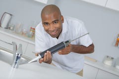 Jeune dépanneur travaillant à la cuisine photos stock Jeune dépanneur travaillant à la cuisine photos stock